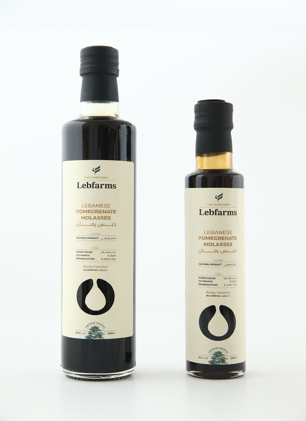 Two bottles of Lebfarms pomegranate molasses on a white background